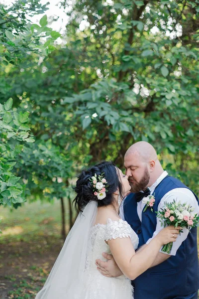 Onların düğün günü üzerinde yeni evliler park, birbirine, gülümseyen bakarak yürüyor.