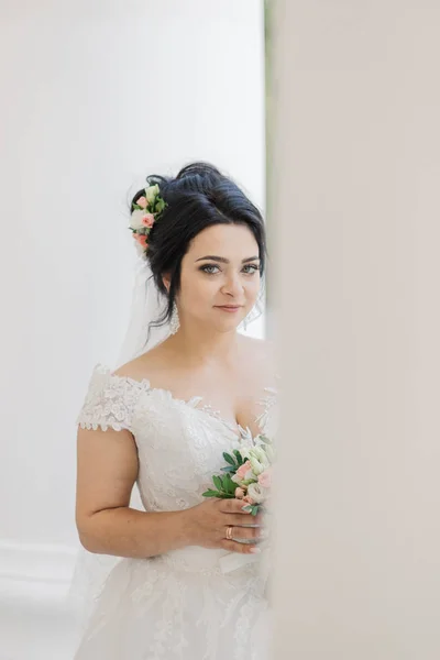 Very beautiful bride is holding a bouquet. — Stock Photo, Image