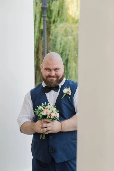 Stílusos szakállas kövér vőlegény esküvői csokor a parkban. — Stock Fotó