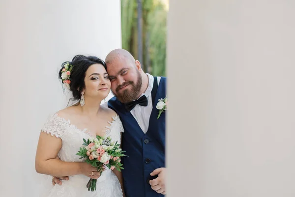 Recién casados en el día de su boda están caminando en el parque, mirándose, sonriendo . — Foto de Stock