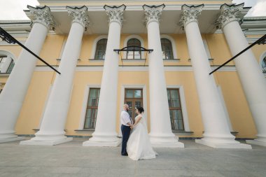Onların düğün günü üzerinde yeni evliler park, birbirine, gülümseyen bakarak yürüyor.