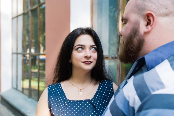 Dos personas enamoradas se abrazan por grandes ventanales en el parque y se miran . —  Fotos de Stock