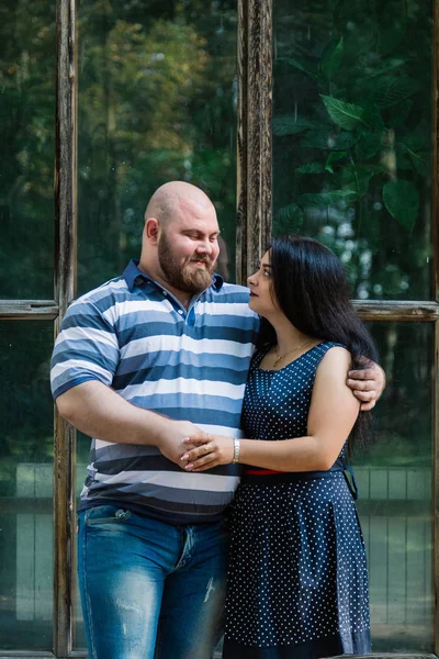 Deux amoureux s'embrassent par de grandes fenêtres dans le parc et se regardent . — Photo