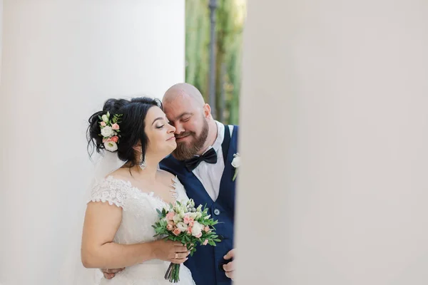 Recién casados en el día de su boda están caminando en el parque, mirándose, sonriendo . — Foto de Stock