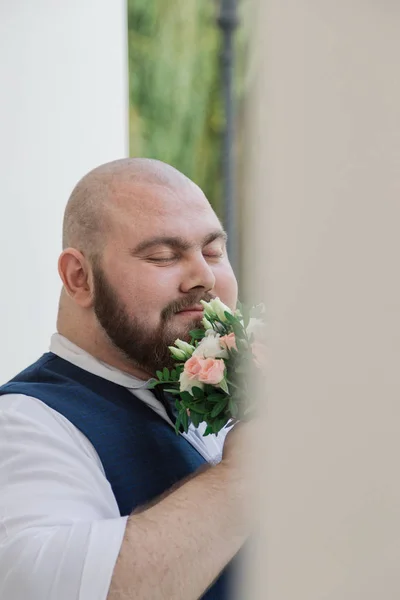 Elegante novio gordo barbudo con ramo de bodas en el parque . — Foto de Stock