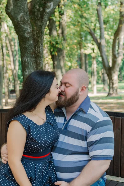 Dos personas enamoradas se sientan en un banco en el parque . —  Fotos de Stock