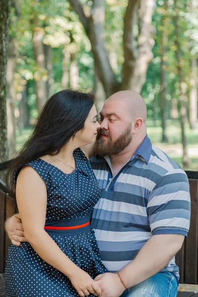 Dos personas enamoradas se sientan en un banco en el parque . —  Fotos de Stock