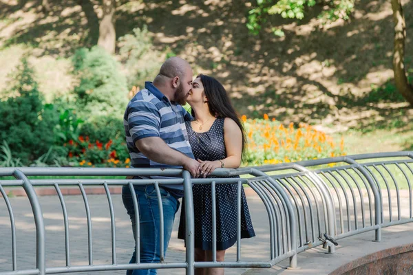 Dos personas enamoradas están de pie en la fuente ociosa en el parque . — Foto de Stock