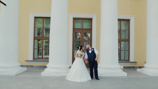 Felices recién casados caminando, abrazándose, besándose en el parque . — Vídeo de stock