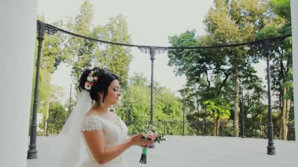 Noiva bonita com buquê de casamento no parque . — Vídeo de Stock