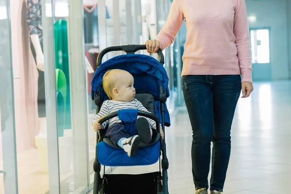 Женщина с ребенком в коляске в торговом центре . — стоковое фото