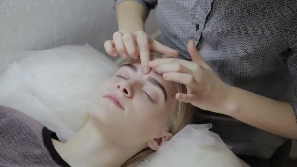 Relaxing woman having a massage for her skin on a face in salon. — Stock Video