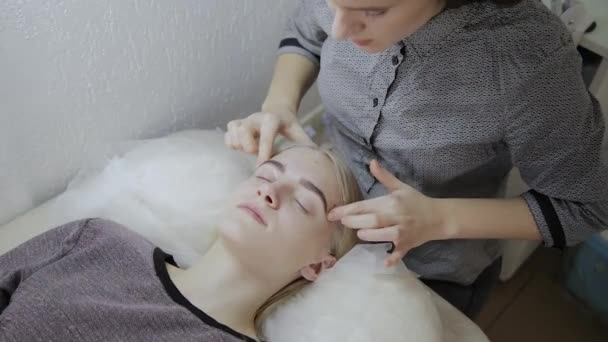 Femme relaxante ayant un massage pour sa peau sur un visage dans le salon . — Video
