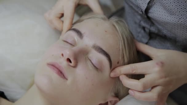 Relajante mujer teniendo un masaje para su piel en una cara en el salón . — Vídeos de Stock