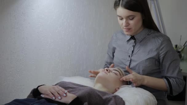 Relajante mujer teniendo un masaje para su piel en una cara en el salón . — Vídeos de Stock