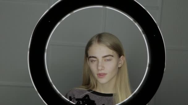 Portrét mladé dívky před prsten světla. — Stock video