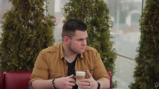 Muži na verandě u stolu pití latte. — Stock video