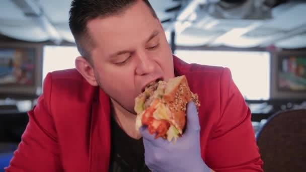 Grasso uomo è brutto mangiare un grande hamburger . — Video Stock