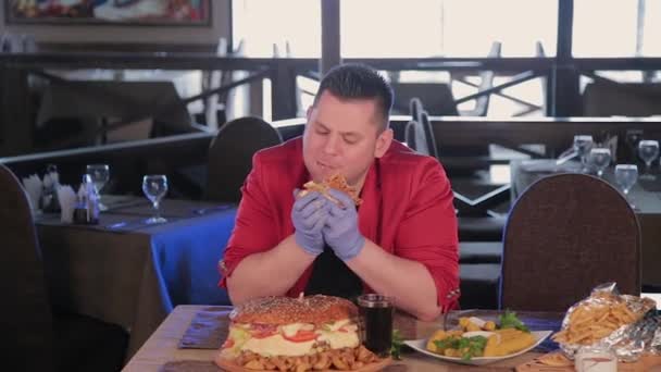 Dicker Mann isst hässlich einen großen Burger. — Stockvideo