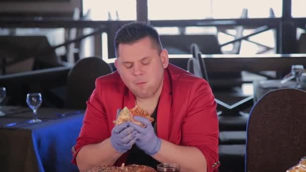 Dikke man is lelijk eten een grote hamburger. — Stockvideo