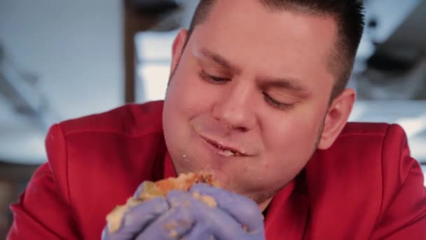 El gordo es feo comiendo una hamburguesa grande. . — Vídeos de Stock