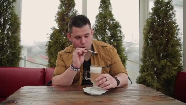 Uomo che beve latte in veranda a tavola . — Video Stock