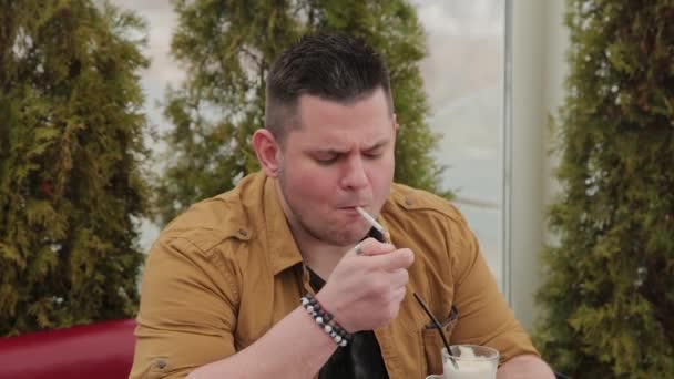 Ο άνθρωπος που καπνίζει ένα τσιγάρο στο τραπέζι. — Αρχείο Βίντεο