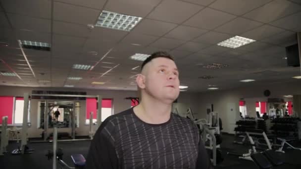 Gros homme exerçant sur le tapis roulant dans la salle de gym . — Video