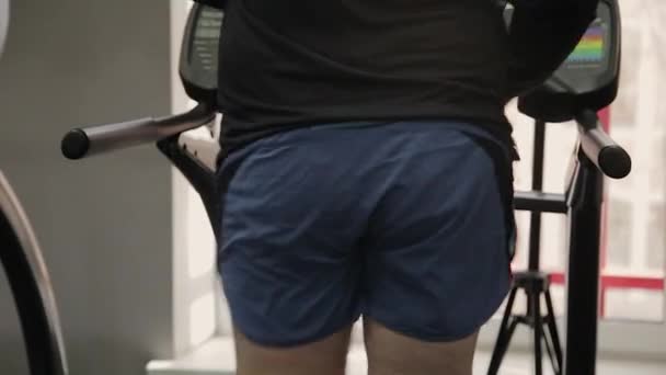 Gros homme exerçant sur le tapis roulant dans la salle de gym . — Video