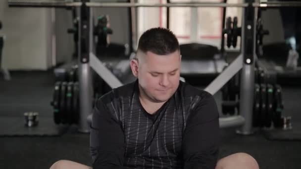 Kövér ember csinál, nyújtás, az emeleten az edzőteremben. — Stock videók
