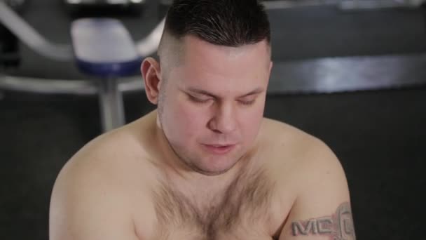 뚱뚱한 남자는 체육관에서 바닥에 스트레칭 하 고. — 비디오