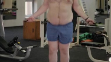 Şişman adam spor salonunda ip atlama.