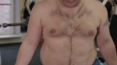 Şişman adam spor salonunda ip atlama.