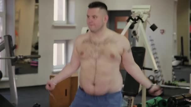 Tlustý Muž, skákání přes švihadlo v posilovně. — Stock video