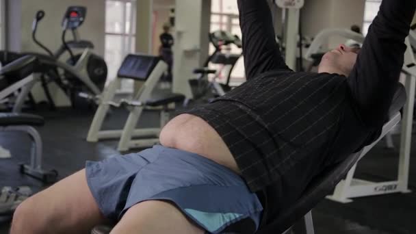Tlustý muž trénink s činkami v posilovně. — Stock video