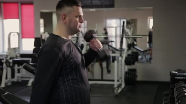 Hombre gordo entrenando con pesas en el gimnasio . — Vídeo de stock