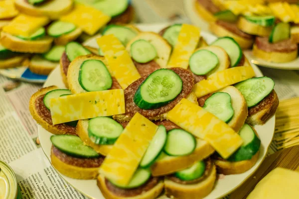 Sandwiches with sausage and cheese and cucumbers on a plate. — Stock Photo, Image