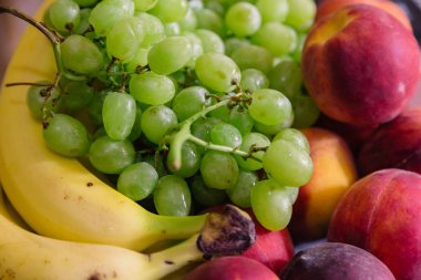 Beyaz bir plaka üzerinde taze çeşitli meyve.