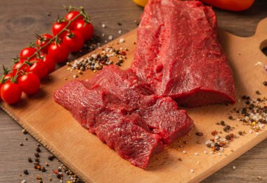 Baharatlar ve sebzeler bir ahşap zemin üzerine ham sığır eti.