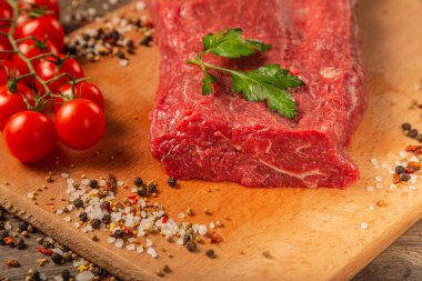 Baharatlar ve sebzeler bir ahşap zemin üzerine ham sığır eti.