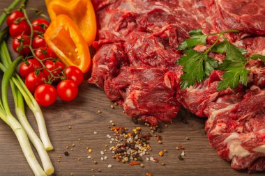 Baharatlar ve sebzeler bir ahşap zemin üzerine ham sığır eti.