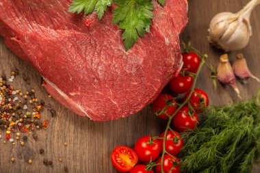 Baharatlar ve sebzeler bir ahşap zemin üzerine ham sığır eti.