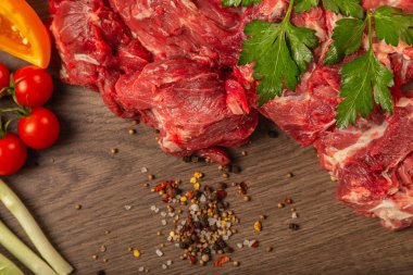Baharatlar ve sebzeler bir ahşap zemin üzerine ham sığır eti.