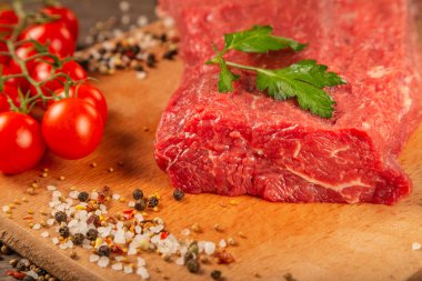Baharatlar ve sebzeler bir ahşap zemin üzerine ham sığır eti.