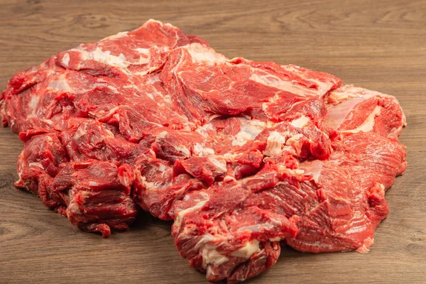 Raw fresh beef on a wooden background, catalog. — Stock Photo, Image
