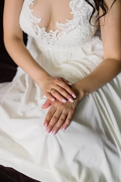 Belles mains d'une jeune mariée dans une robe de mariée . — Photo