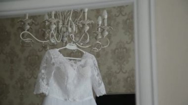 Güzel düğün elbisesi içinde büyük bir avize asılı.