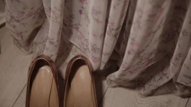 perde tarafından zemin üzerinde altın kadın ayakkabı.