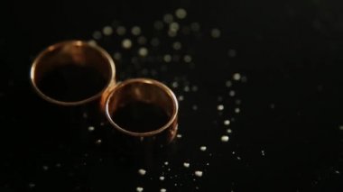 Alyans karanlık yüzeyinde yansıma ve su ile yalan. Işık yakın makro ile parlayan.