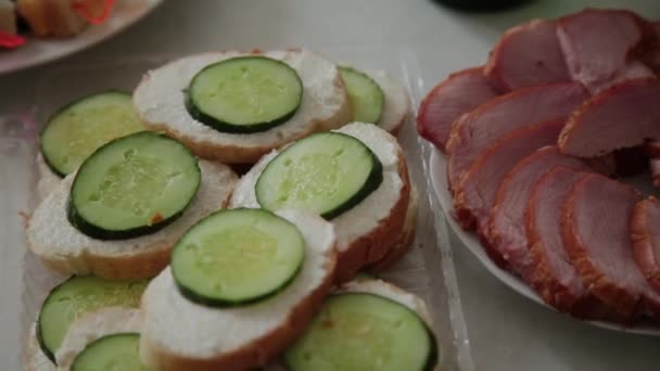 Sandwiches met komkommer boter en worst op tafel. — Stockvideo